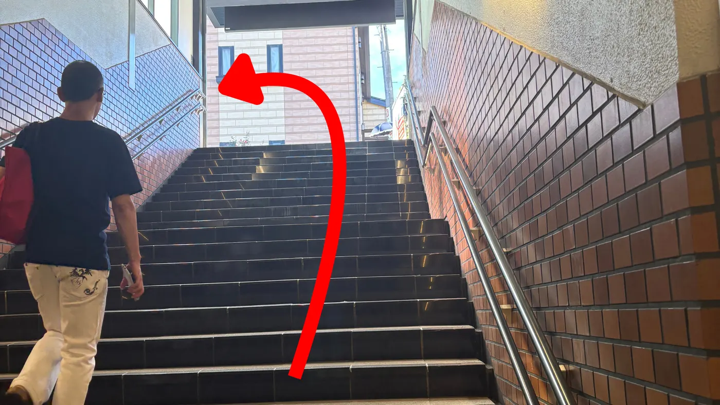 駅構内の階段を上って左方向へ進む様子